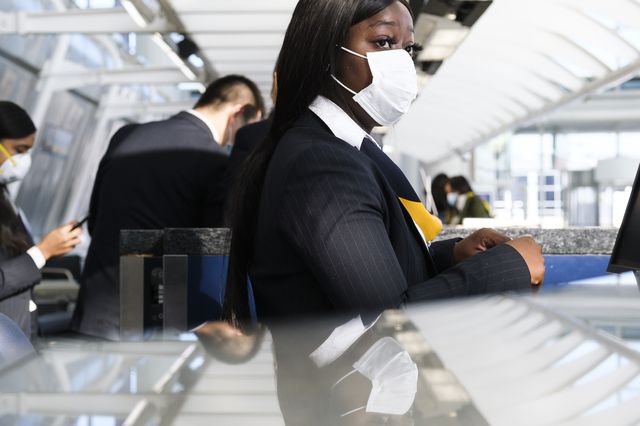 A woman wearing a medical mask checks in passengers at a China Eastern desk at John F. Kennedy international airport in New York.